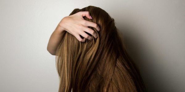 pexels-photo-1159334-1159334 An artistic close-up of a woman's long brunette hair held gently by her hand, emphasizing texture and color.