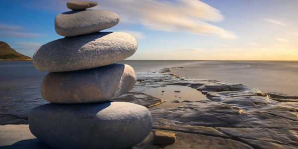 pexels-photo-289586-289586 A serene stack of stones on the rocky seashore during a peaceful sunrise, embodying balance and zen.
